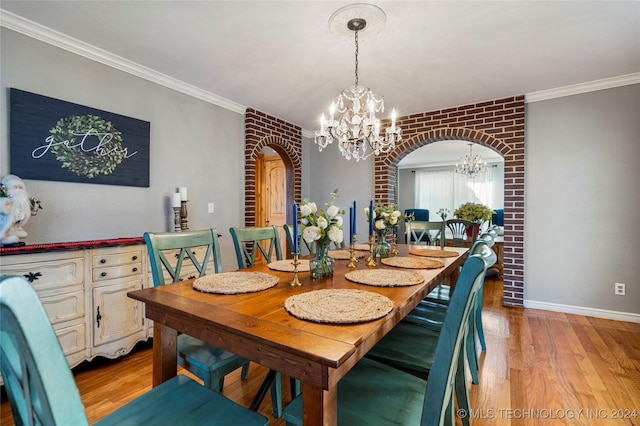 dining area with a chandelier, light wood-type flooring, crown molding, and brick wall