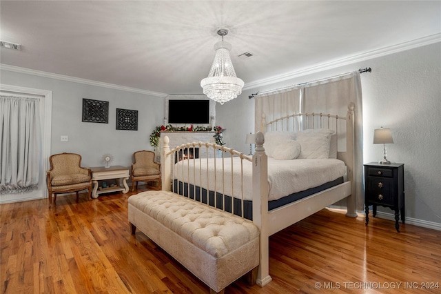 bedroom with hardwood / wood-style flooring, ornamental molding, and an inviting chandelier