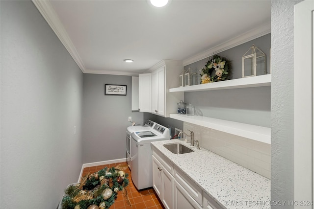 clothes washing area featuring cabinets, sink, washing machine and dryer, ornamental molding, and light tile patterned floors