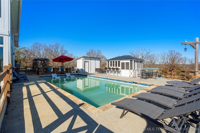 view of pool with a patio area and a shed