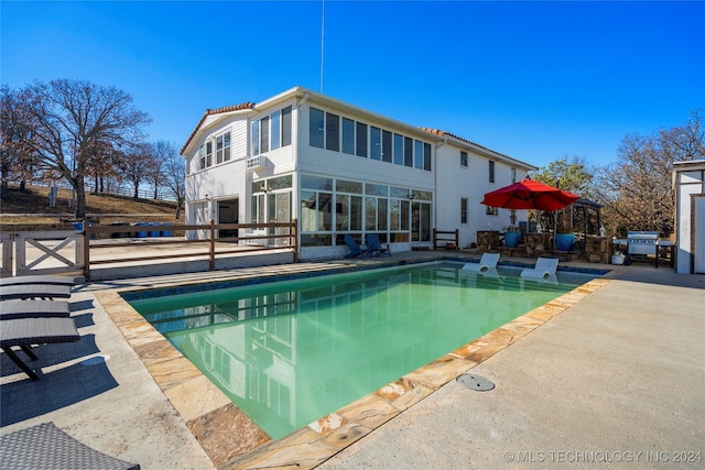 back of property with a patio and a sunroom