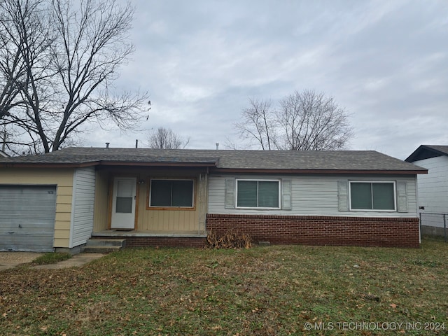 single story home featuring a front yard and a garage