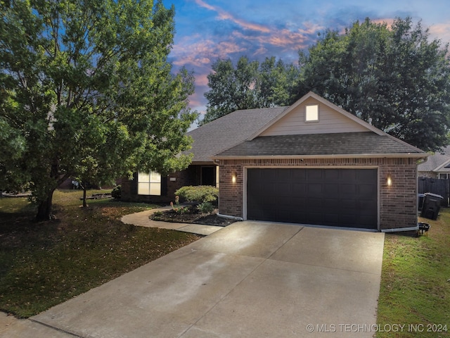 view of front of home with a garage and a lawn