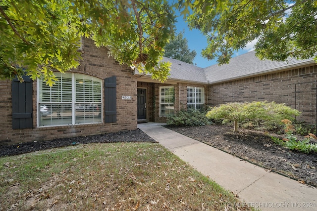 view of exterior entry with a lawn