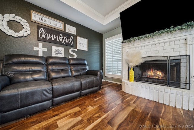 living room with crown molding, a fireplace, and hardwood / wood-style flooring