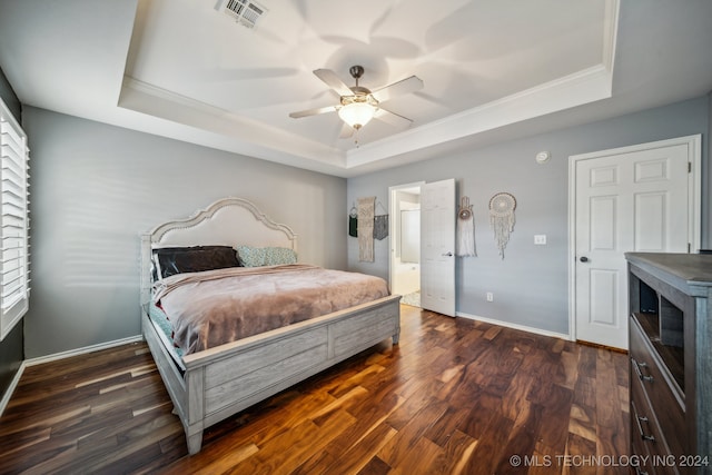 bedroom featuring multiple windows, a raised ceiling, ceiling fan, and dark wood-type flooring