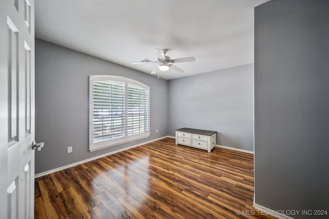 empty room with ceiling fan and dark wood-type flooring