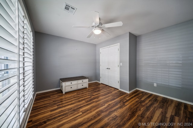 unfurnished bedroom featuring ceiling fan and dark hardwood / wood-style flooring