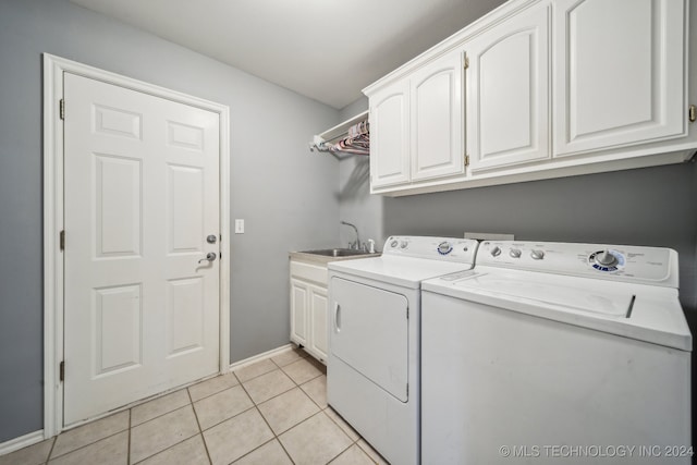 laundry room with light tile patterned flooring, cabinets, sink, and washing machine and clothes dryer