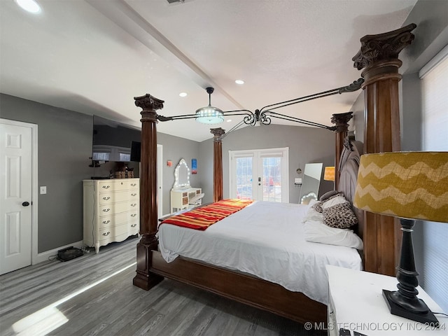 bedroom with access to exterior, hardwood / wood-style floors, and vaulted ceiling with beams