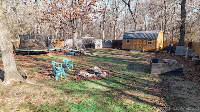 view of yard with a trampoline and a storage unit