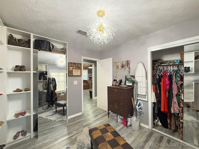 bedroom with a chandelier, a closet, hardwood / wood-style floors, and a textured ceiling