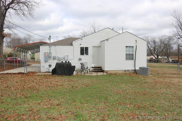 rear view of property with central AC, a carport, and a yard