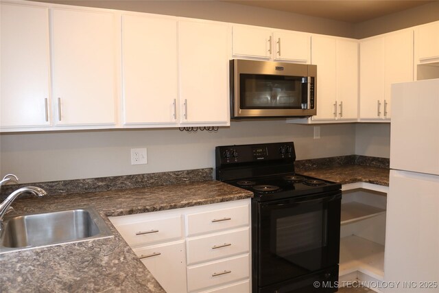 kitchen with white cabinetry, sink, black electric range, and white fridge