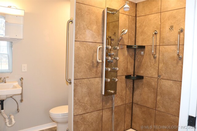 bathroom featuring a tile shower and toilet