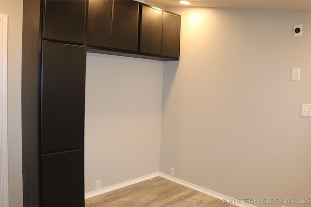 interior space featuring cabinets, light wood-type flooring, and electric dryer hookup