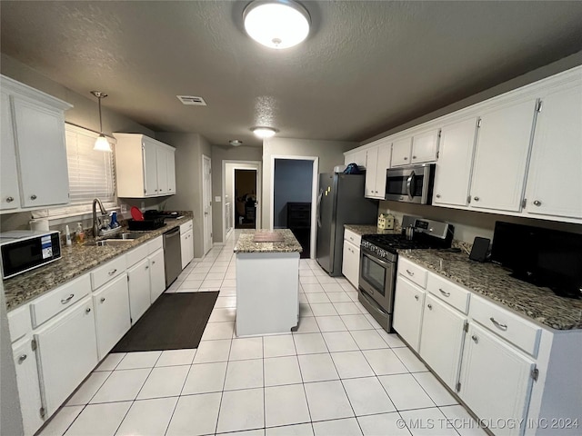 kitchen featuring a kitchen island, white cabinetry, and stainless steel appliances