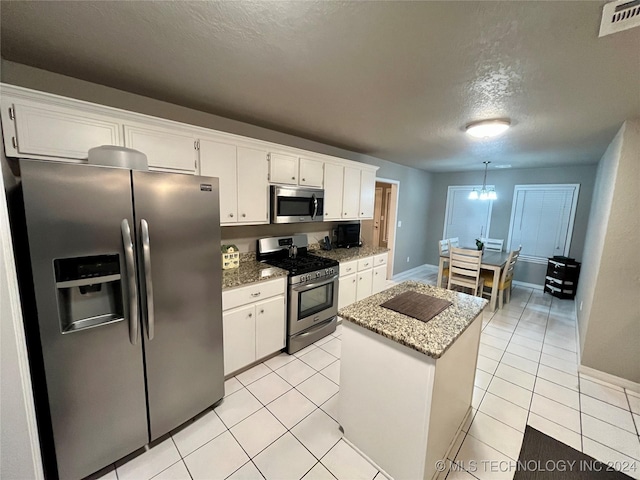 kitchen featuring white cabinetry, a center island, a textured ceiling, and appliances with stainless steel finishes