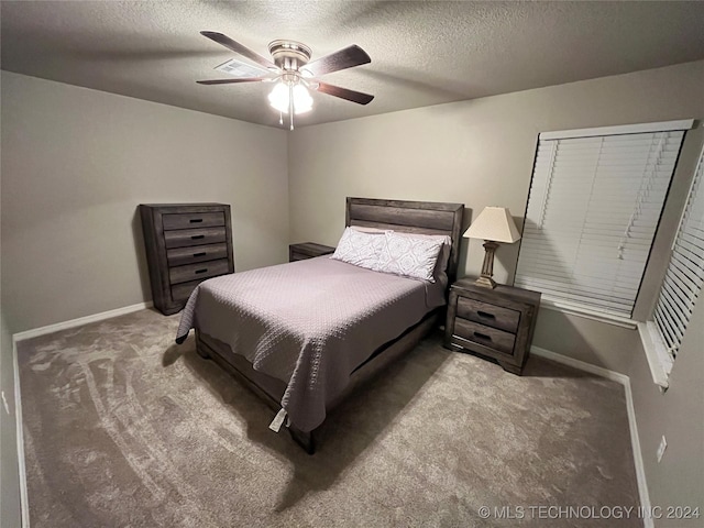 carpeted bedroom with ceiling fan and a textured ceiling