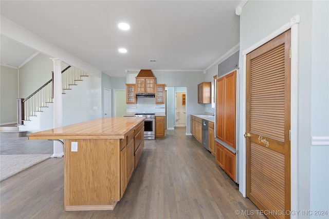 kitchen with ornamental molding, a breakfast bar, stainless steel appliances, hardwood / wood-style floors, and a center island