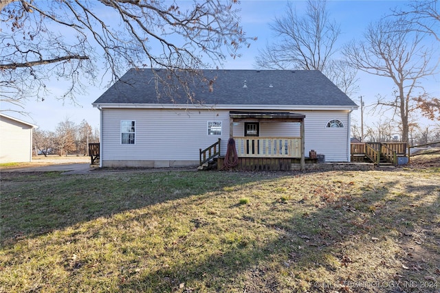 rear view of house with a lawn and a deck