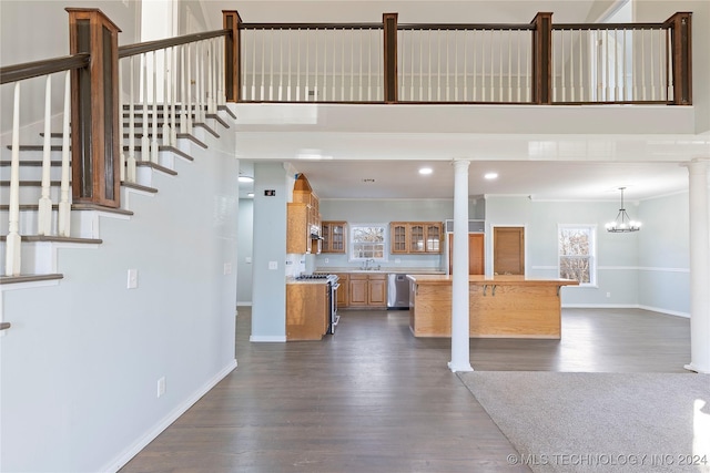 interior space with dark hardwood / wood-style flooring, decorative columns, plenty of natural light, and a notable chandelier