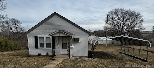 bungalow-style home with a front lawn and a carport