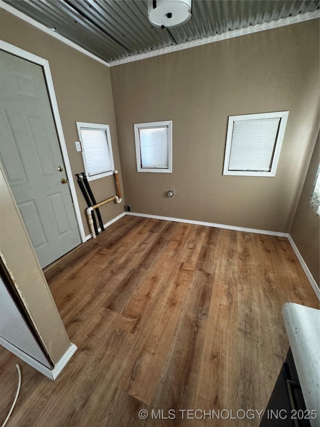 laundry area with wood-type flooring and crown molding