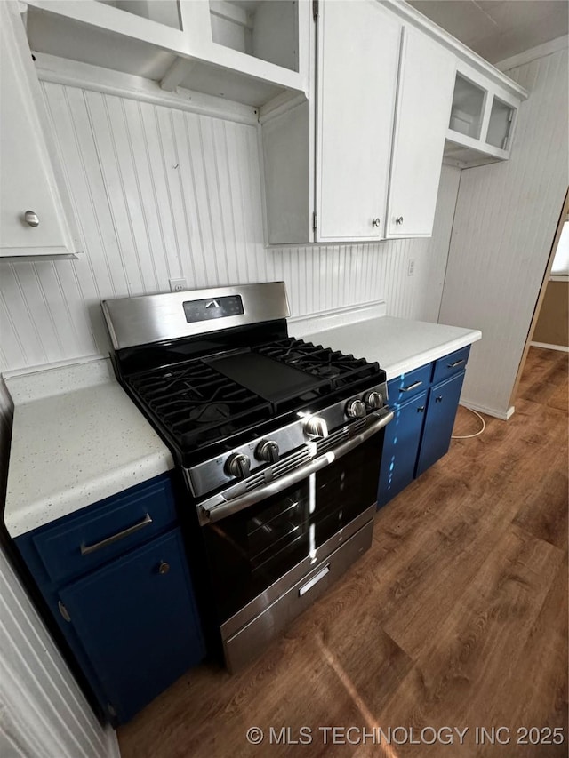 kitchen featuring white cabinets, dark wood-type flooring, blue cabinetry, and stainless steel gas range oven