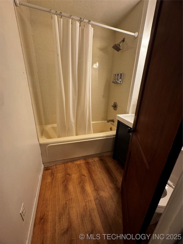 bathroom with hardwood / wood-style flooring, a textured ceiling, shower / tub combo, and vanity