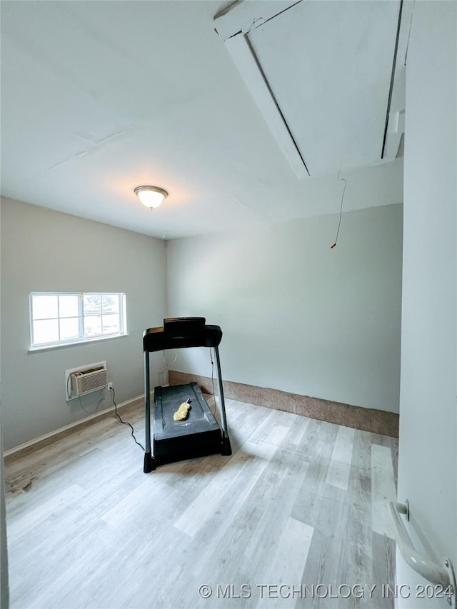 interior space with a wall mounted AC and light hardwood / wood-style flooring