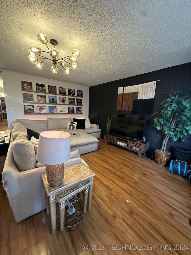 living room featuring hardwood / wood-style floors, a textured ceiling, and a notable chandelier