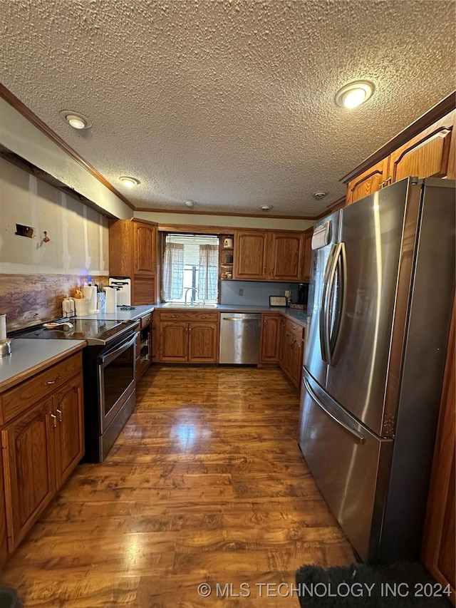 kitchen with appliances with stainless steel finishes, dark hardwood / wood-style flooring, a textured ceiling, and sink