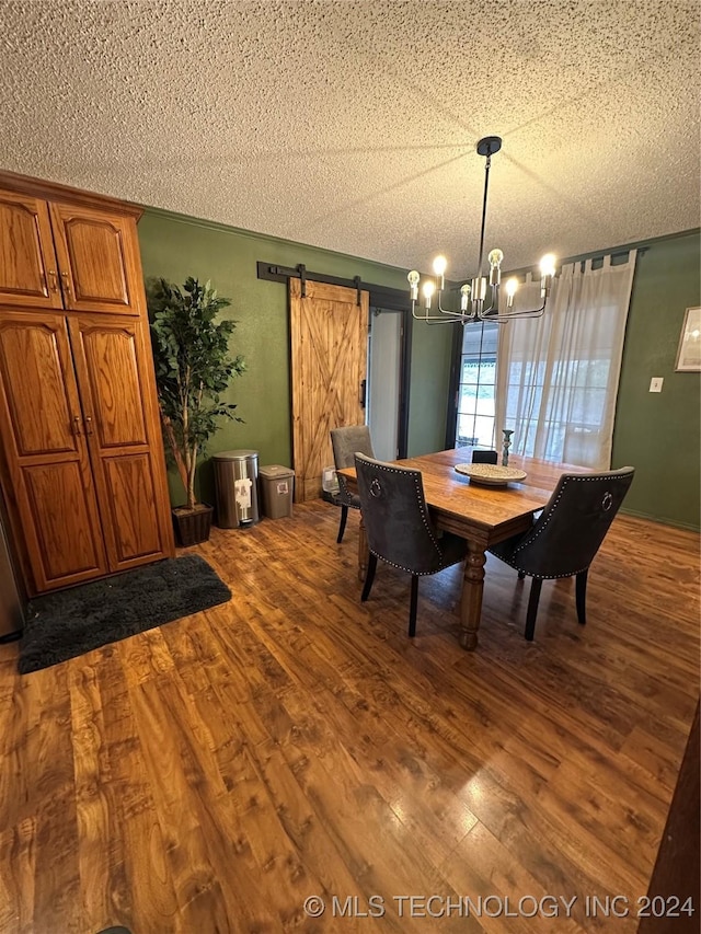 unfurnished dining area with hardwood / wood-style flooring, a notable chandelier, a barn door, and a textured ceiling