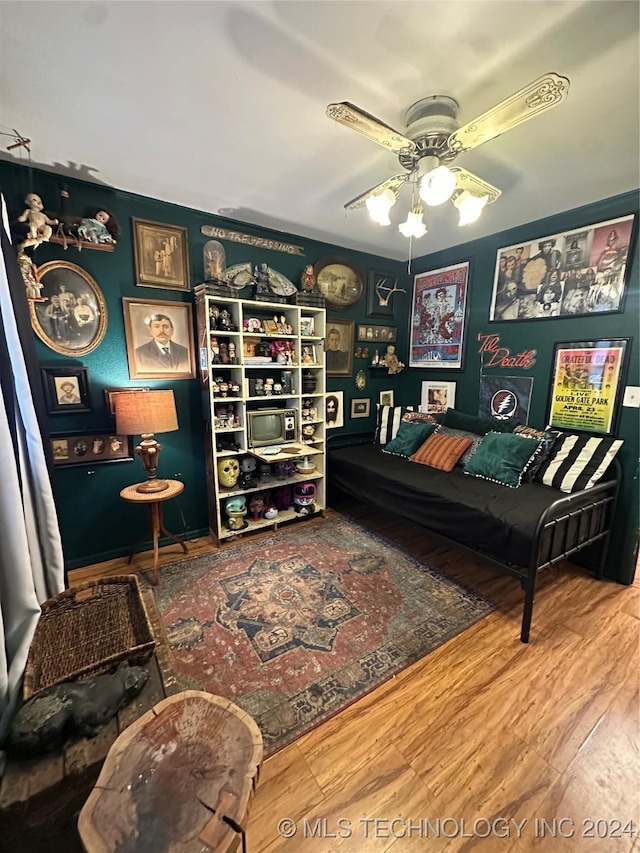 living area with ceiling fan and wood-type flooring