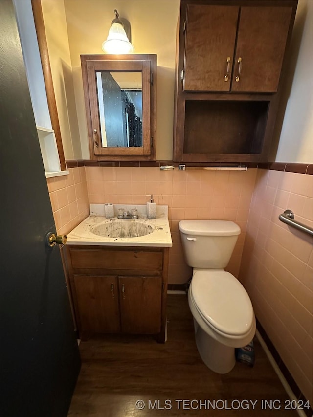 bathroom with hardwood / wood-style floors, vanity, tile walls, and toilet