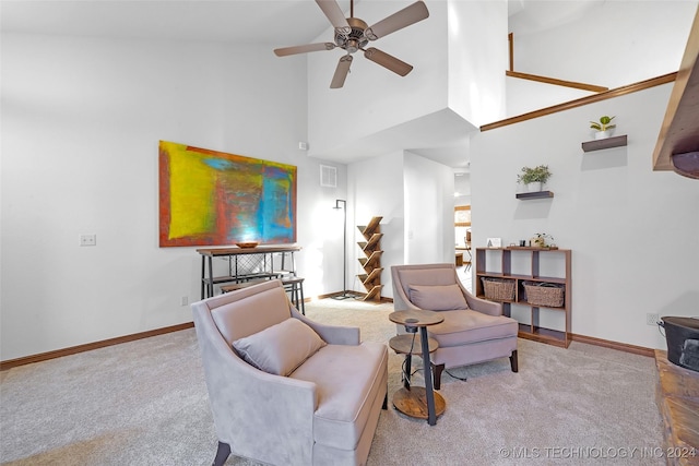 carpeted living room with ceiling fan and high vaulted ceiling