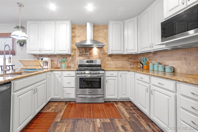 kitchen featuring wall chimney exhaust hood, white cabinetry, and appliances with stainless steel finishes