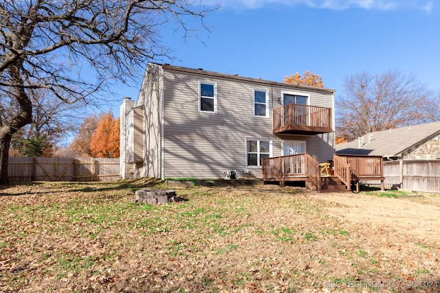 rear view of property with a balcony and a yard