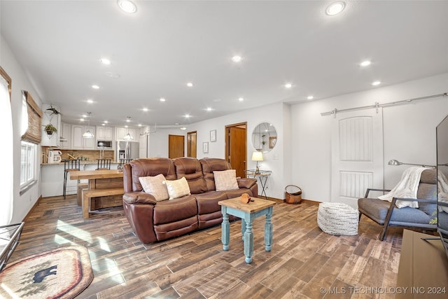 living room with a barn door and hardwood / wood-style floors