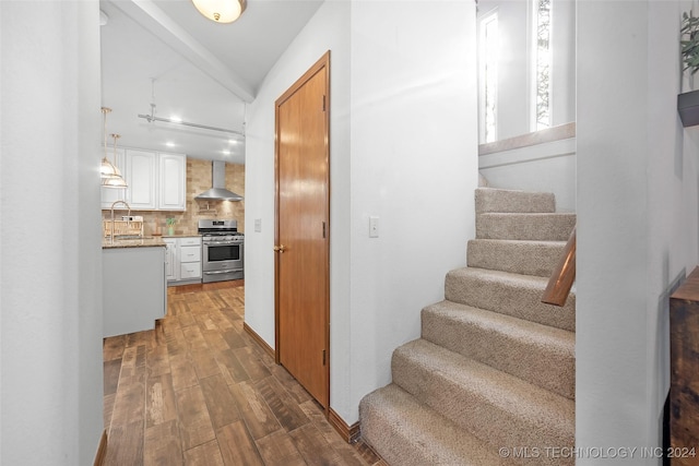 staircase with hardwood / wood-style flooring and sink