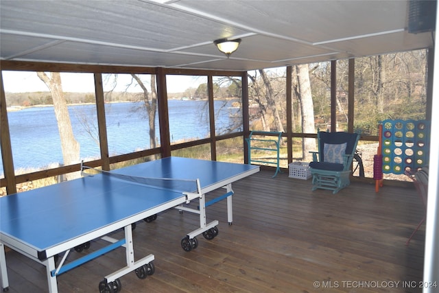 playroom with dark hardwood / wood-style flooring, a water view, and expansive windows