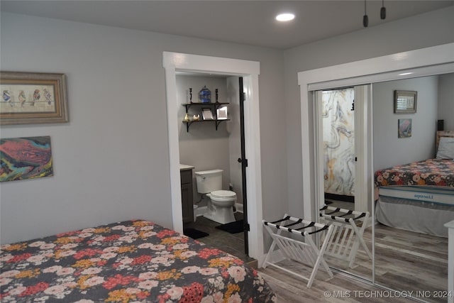 bedroom featuring dark wood-type flooring and connected bathroom