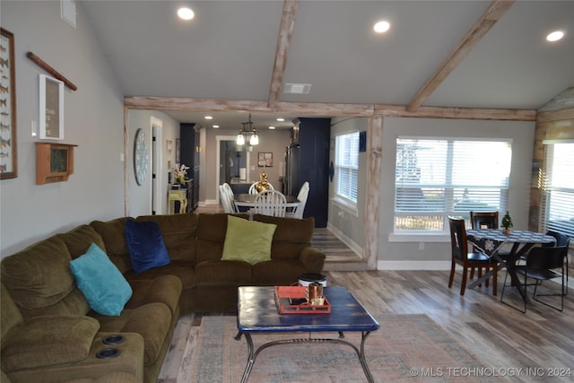 living room with vaulted ceiling with beams, hardwood / wood-style floors, and a notable chandelier