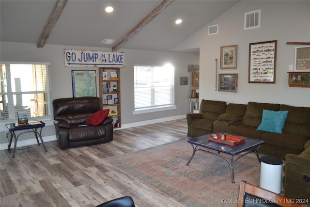 living room with wood-type flooring, lofted ceiling with beams, and a wealth of natural light