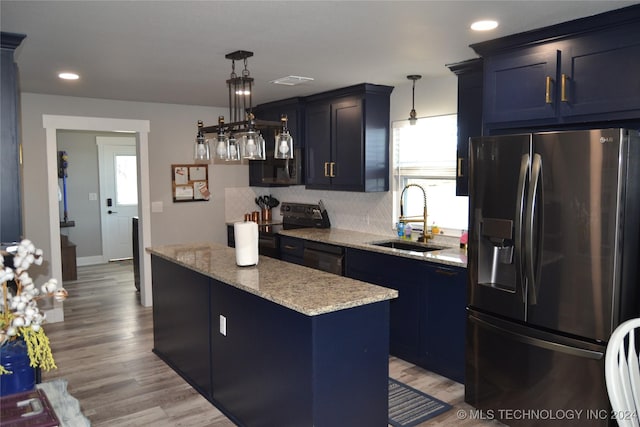 kitchen with stainless steel appliances, a healthy amount of sunlight, sink, a kitchen island, and hanging light fixtures