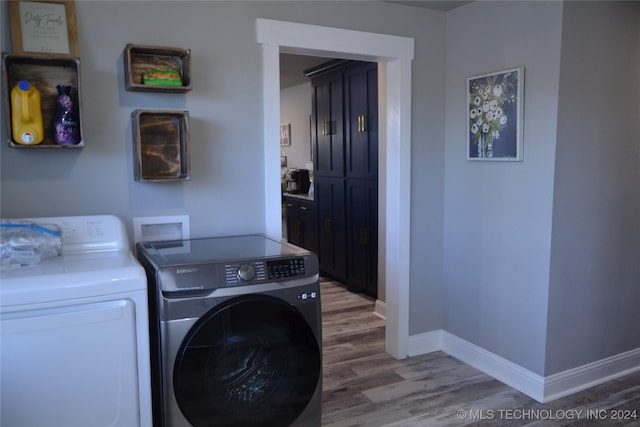 washroom with washer and dryer and hardwood / wood-style floors