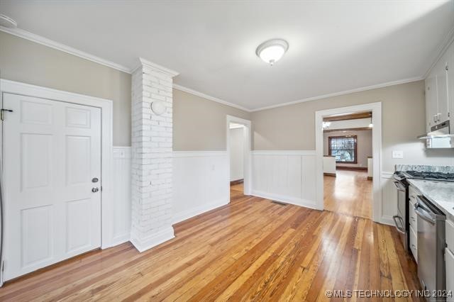 unfurnished dining area featuring light hardwood / wood-style floors and ornamental molding