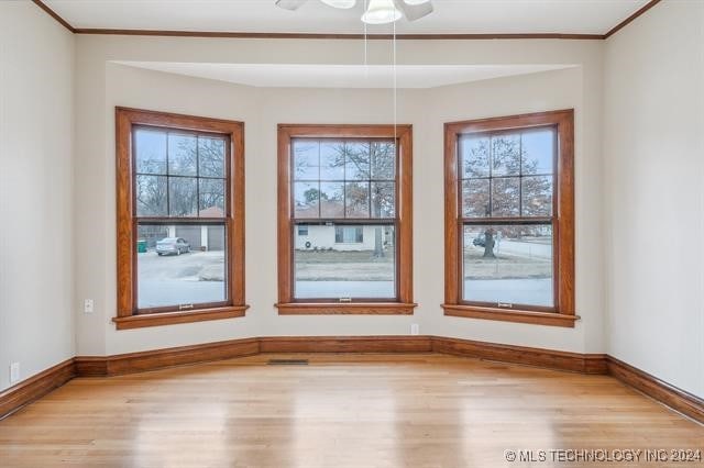 spare room with light hardwood / wood-style floors, ceiling fan, and ornamental molding