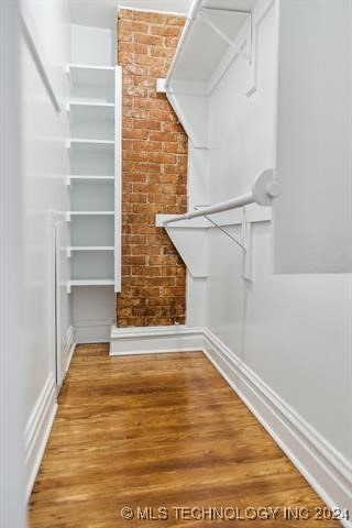 walk in closet with hardwood / wood-style flooring